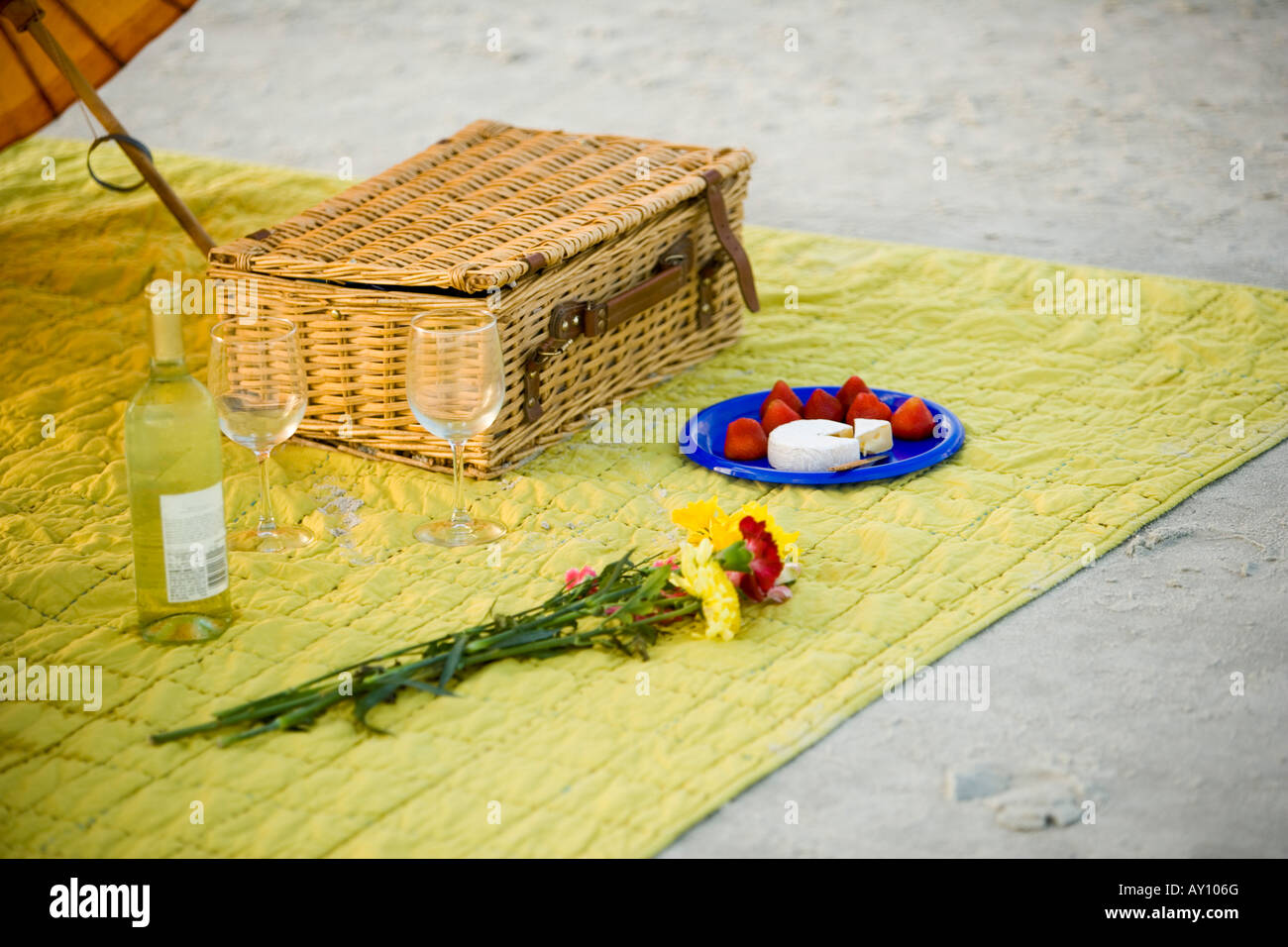 Picnic basket with beverage and flowers on mat at the beach Stock Photo ...