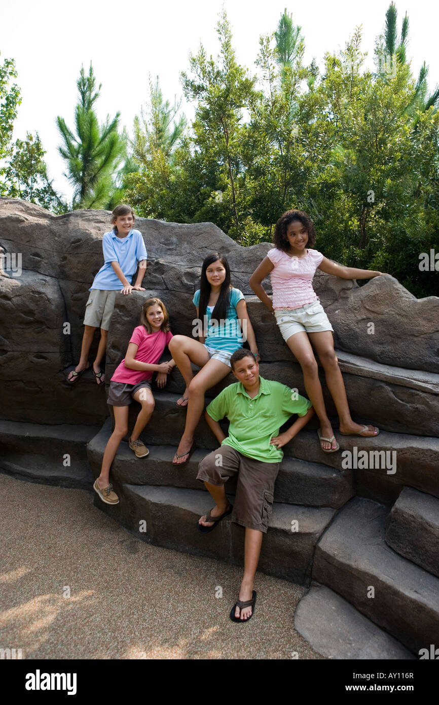 Portrait of cheerful teenagers sitting on rocks Stock Photo - Alamy