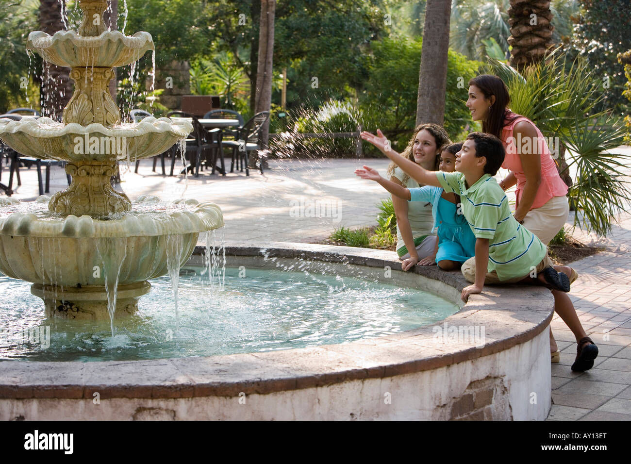 People sitting together by a water fountain Stock Photo Alamy