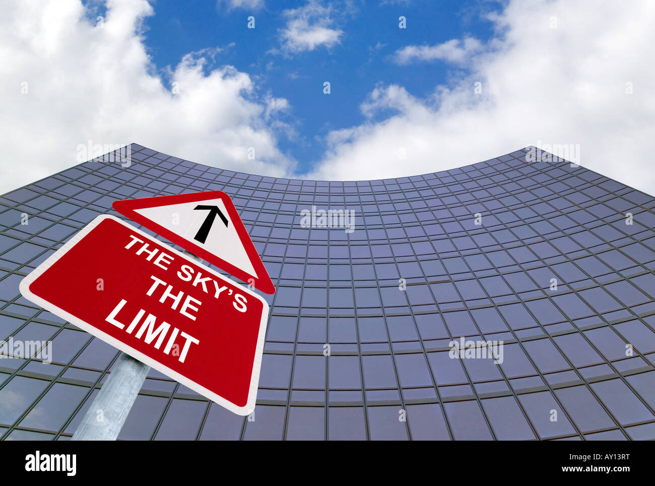 A signpost with The Skys the Limit outside a modern glass office building Stock Photo