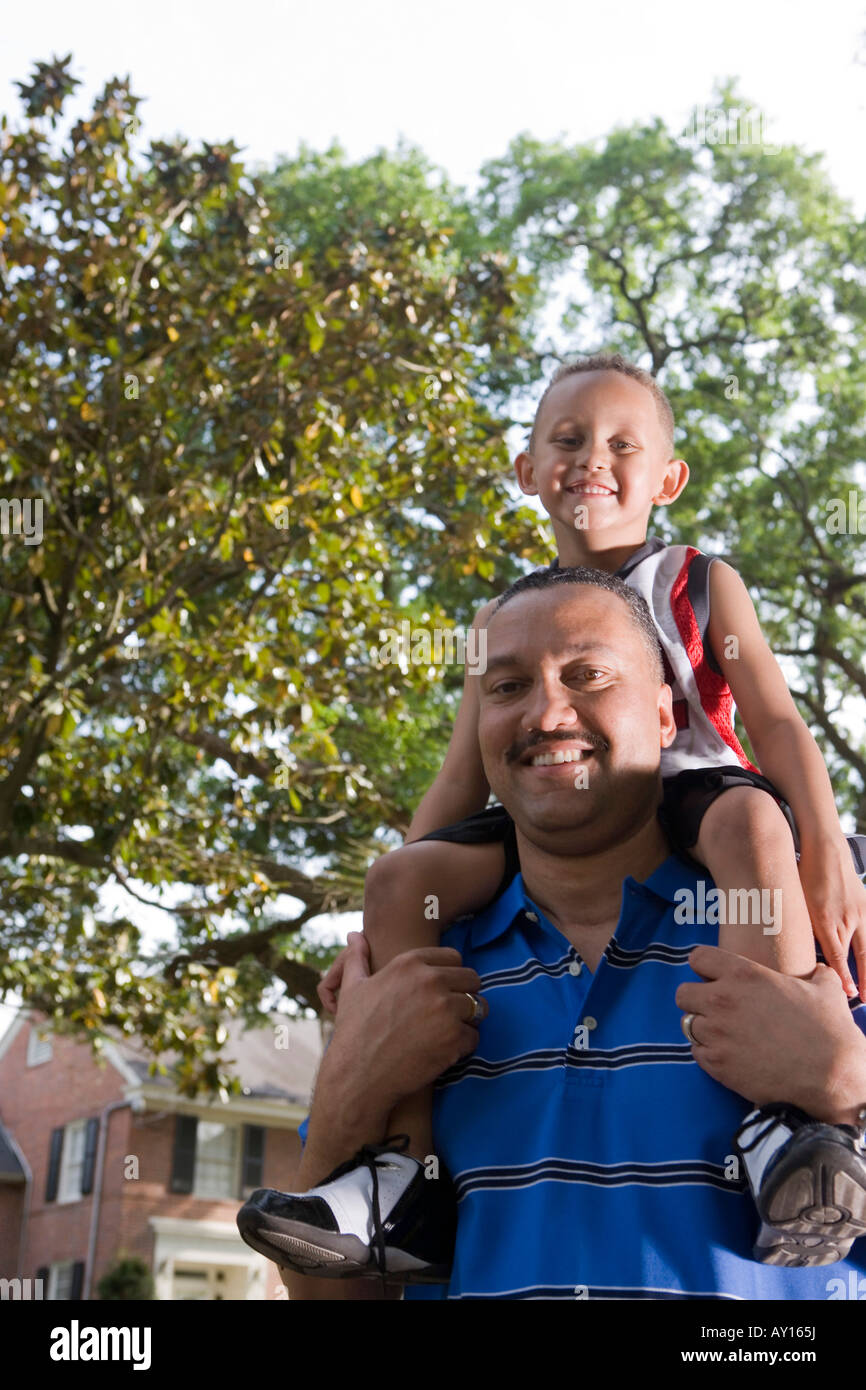 Portrait of a father carrying son on his shoulder Stock Photo - Alamy