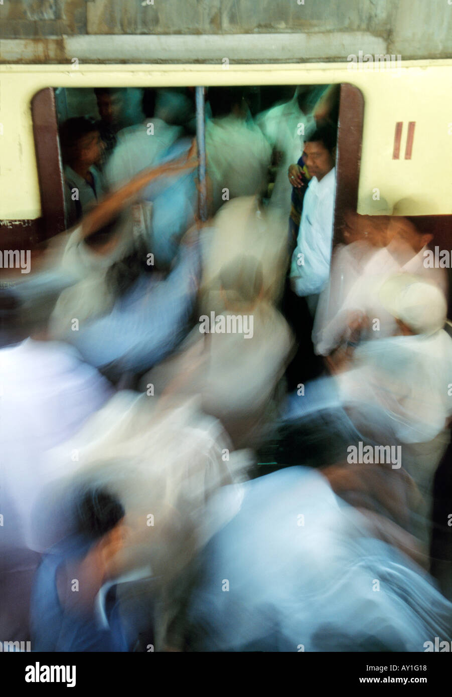 Streaming commuters and travellers in chaotic motion : a daily occurence  at busy domestic train stations in Mumbai, India. Stock Photo