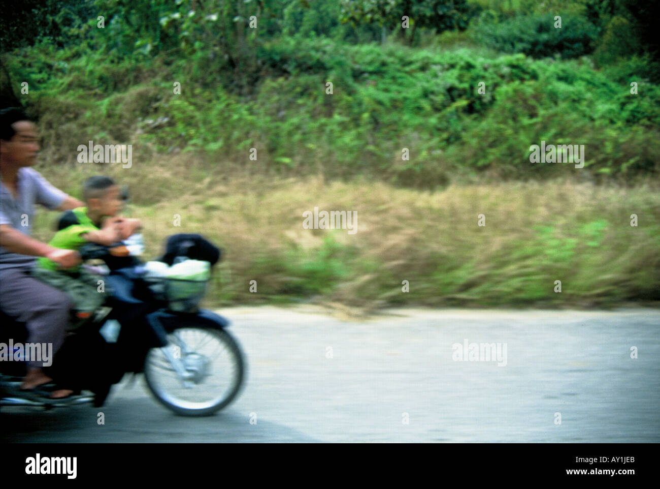 Thailand Chiang Mai Province, Northern Thailand Chang Mai Motorcyclist with child - no helmets - driving in Chang Mai. Stock Photo