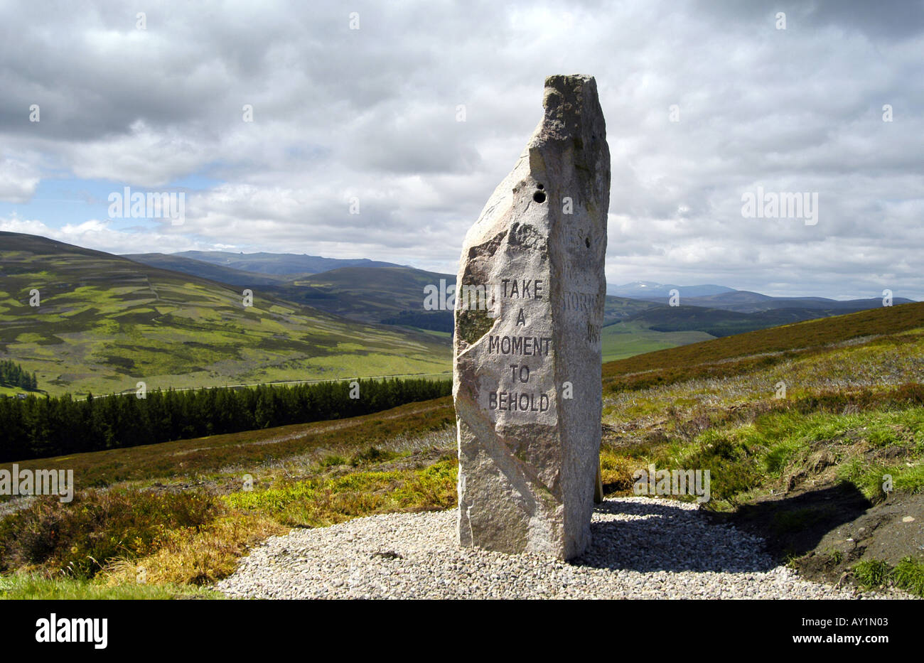 Heather in flower & landmarks of Scotland;  Standing Stone Monolith engraved on Scottish heather moors 'Take a moment to behold' Lecht road Scotland. Stock Photo