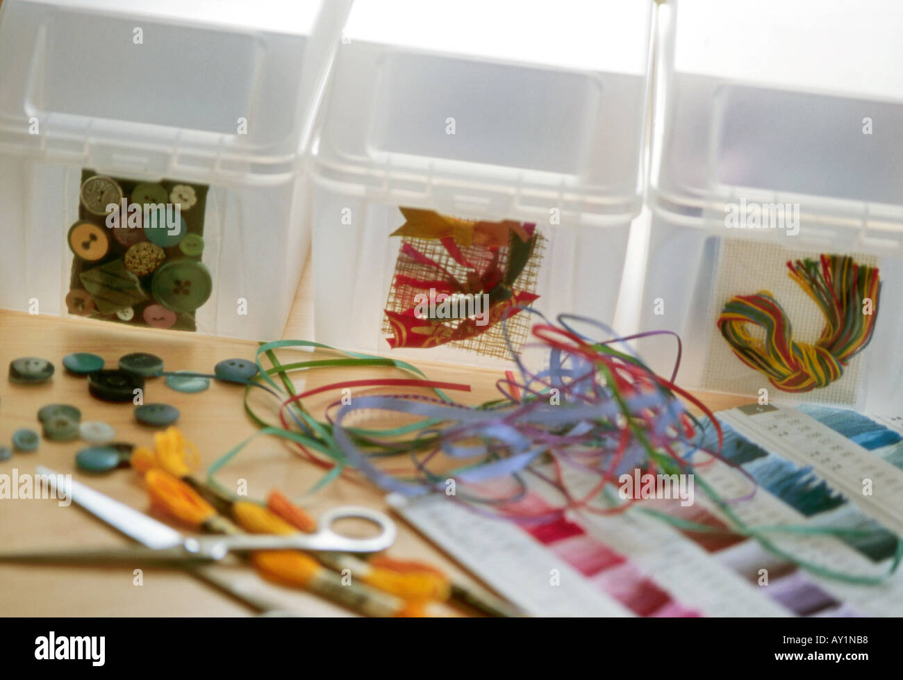 Translucent plastic boxes labelled with examples of their contents buttons and threads for embroidery Stock Photo