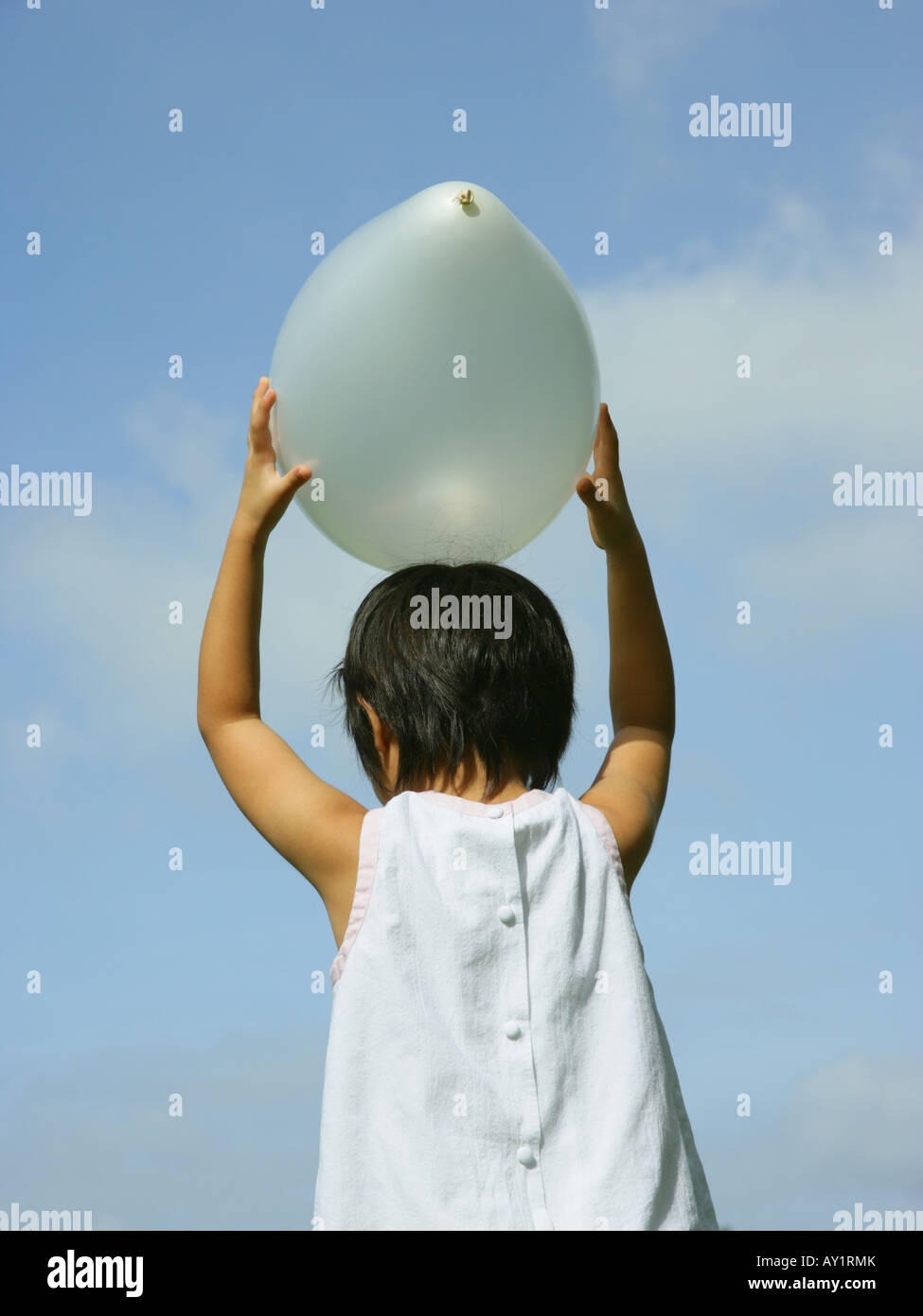 Girl holding balloon above head hi-res stock photography and images - Alamy