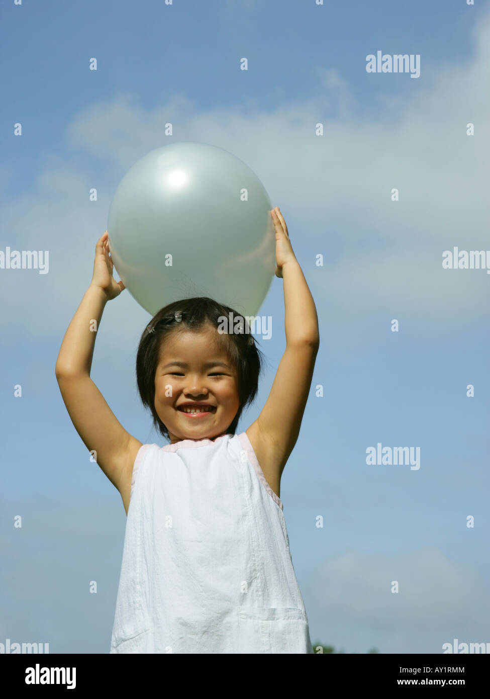 Portrait of a girl holding a balloon above her head Stock Photo