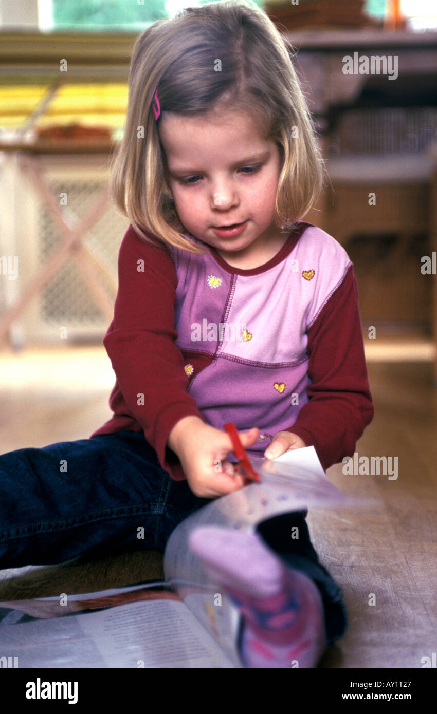 Girl cutting paper with scissors Stock Photo