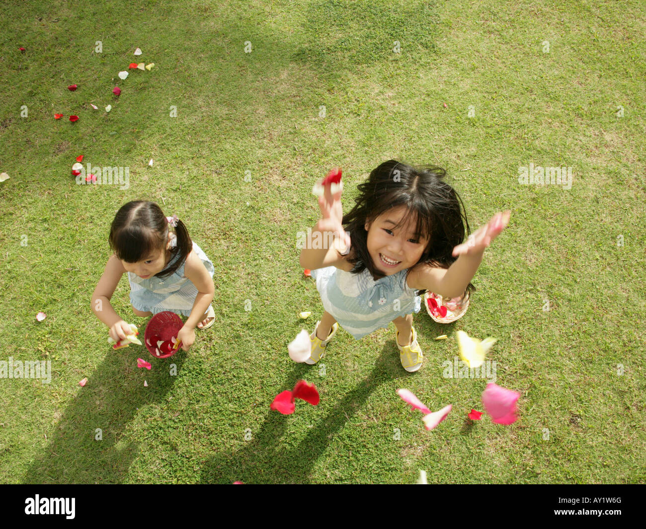 Portrait of two girls throwing rose petals in the air Stock Photo Alamy