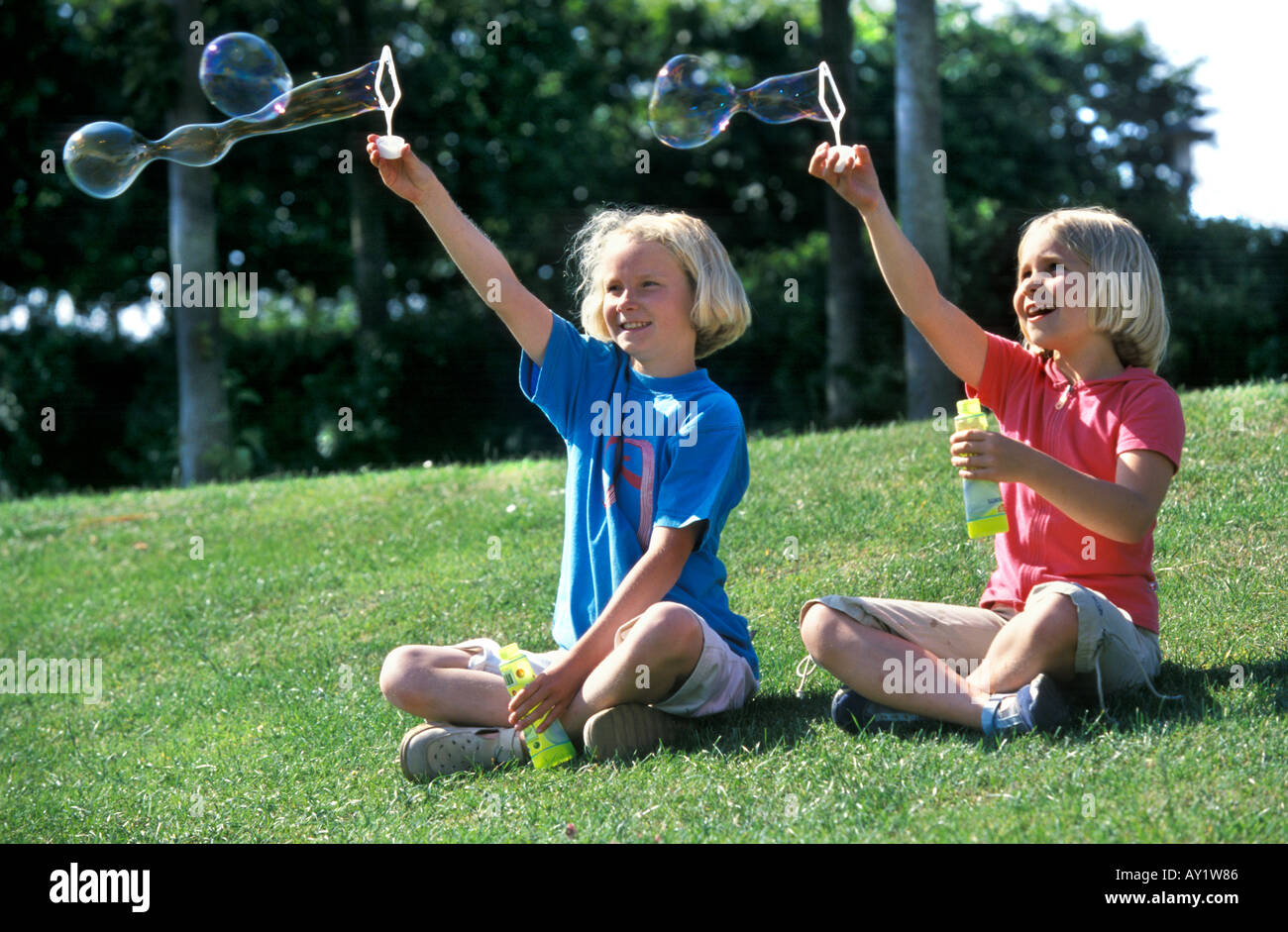 Two blond girls blowing bubbles Stock Photo
