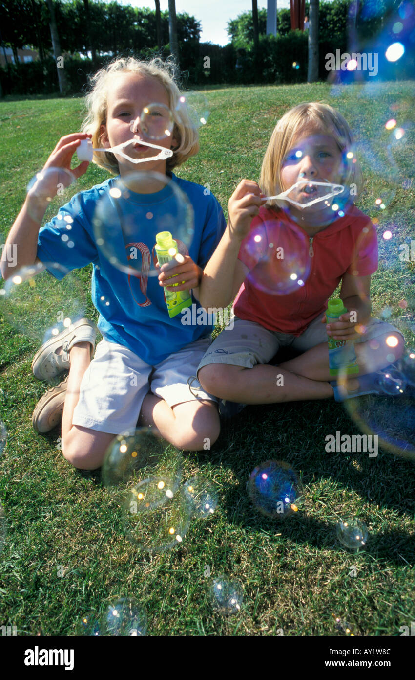 Two blond girls blowing bubbles Stock Photo