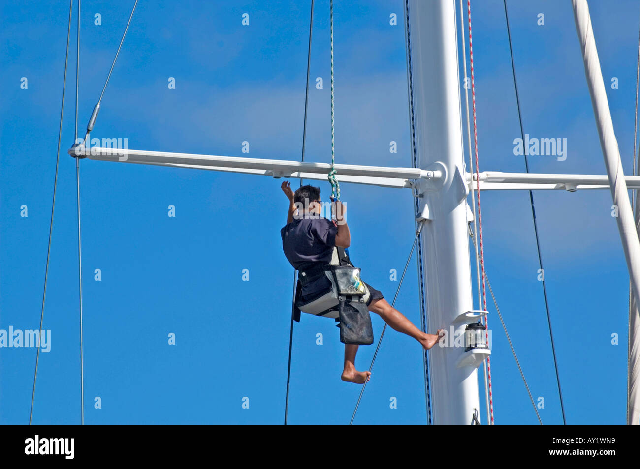a man working on the mast of a ship Stock Photo