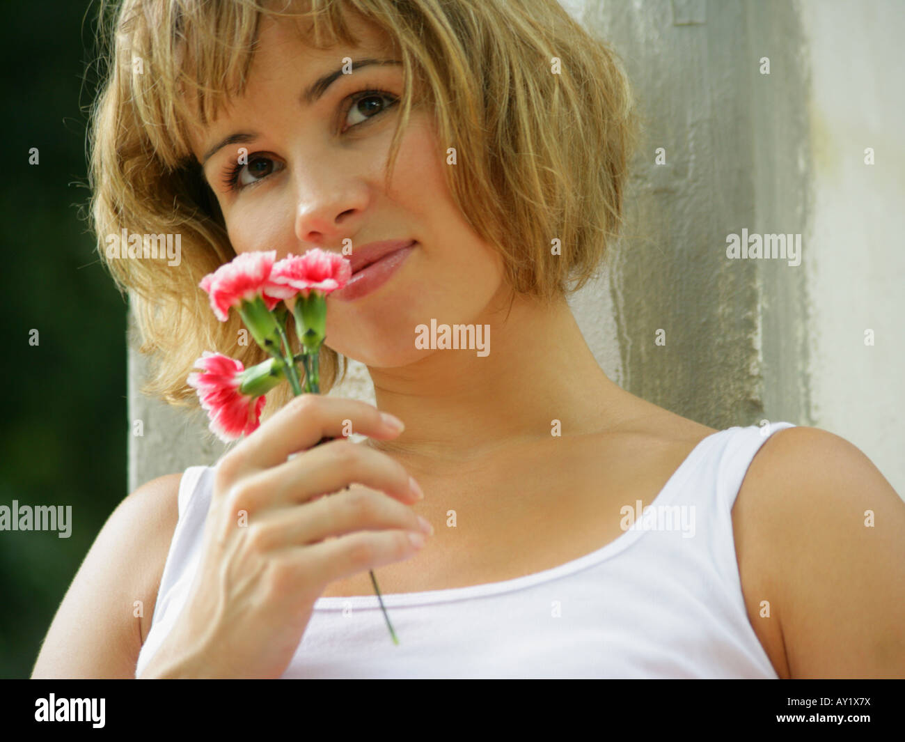 Close-up of a young woman smelling flowers (Carnation Stock Photo - Alamy