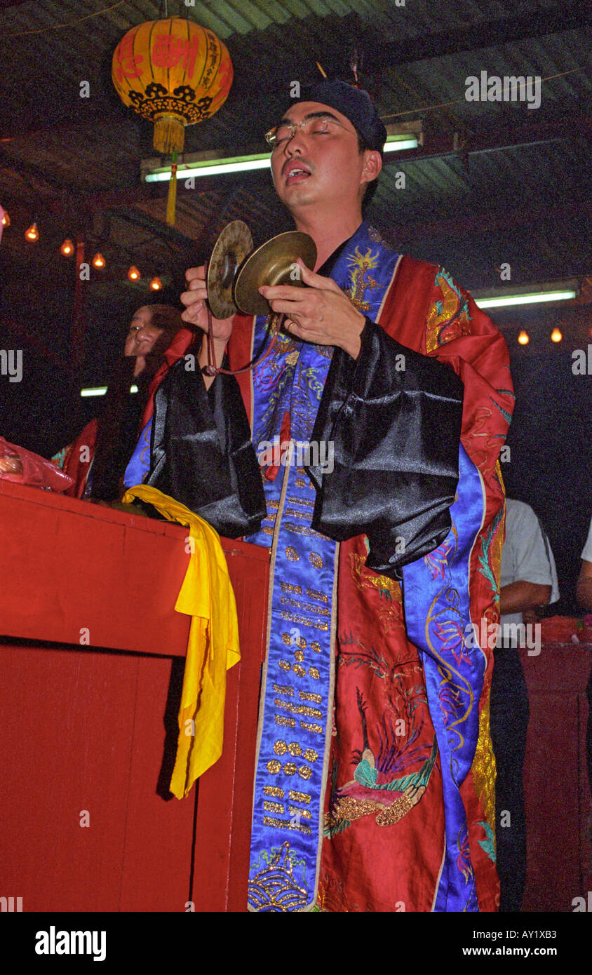 A Taoist priest dressed in traditional clothing offering prayers during the Nine Emperor Gods festival Stock Photo