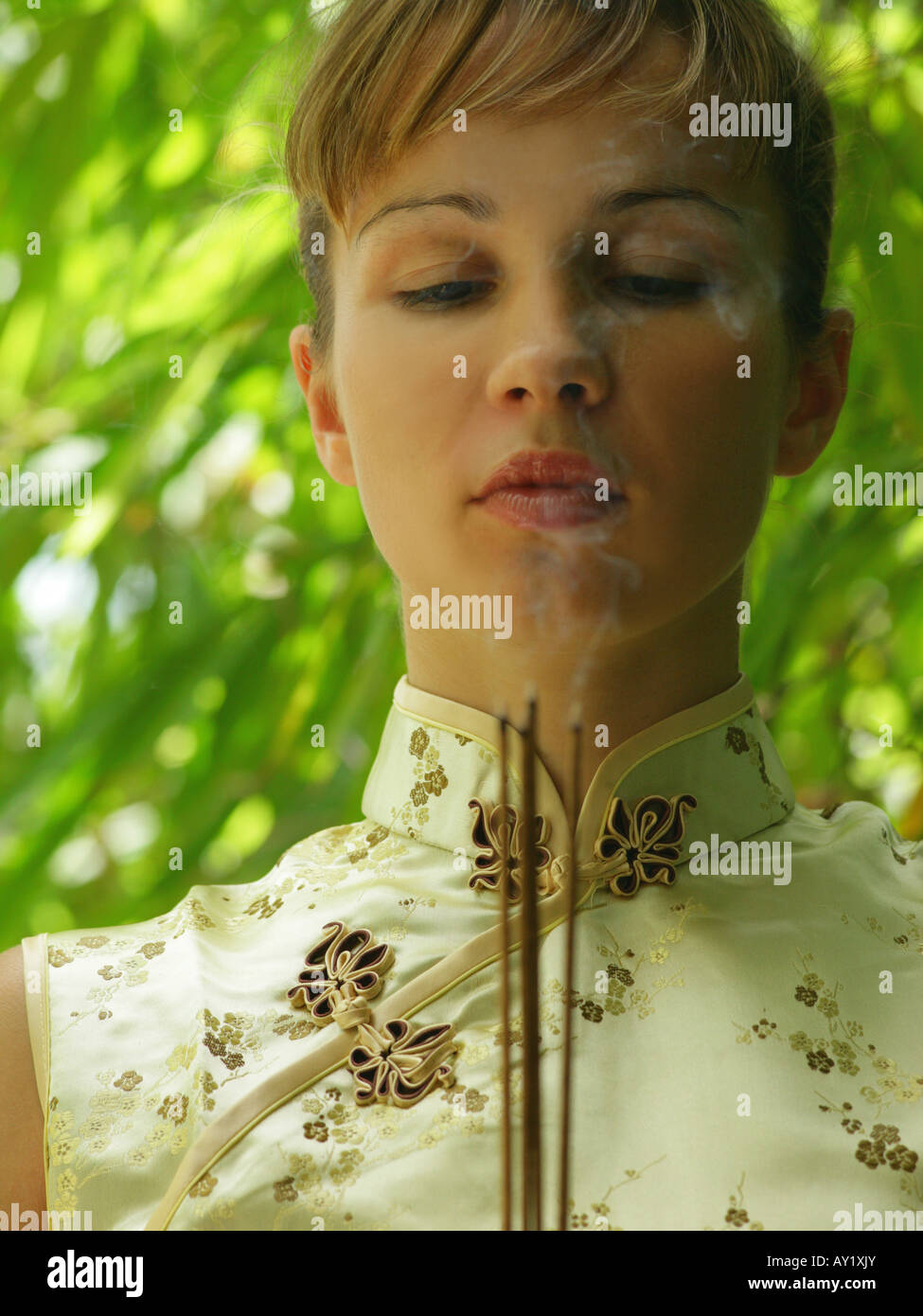 Close-up of a young woman holding incense sticks Stock Photo - Alamy