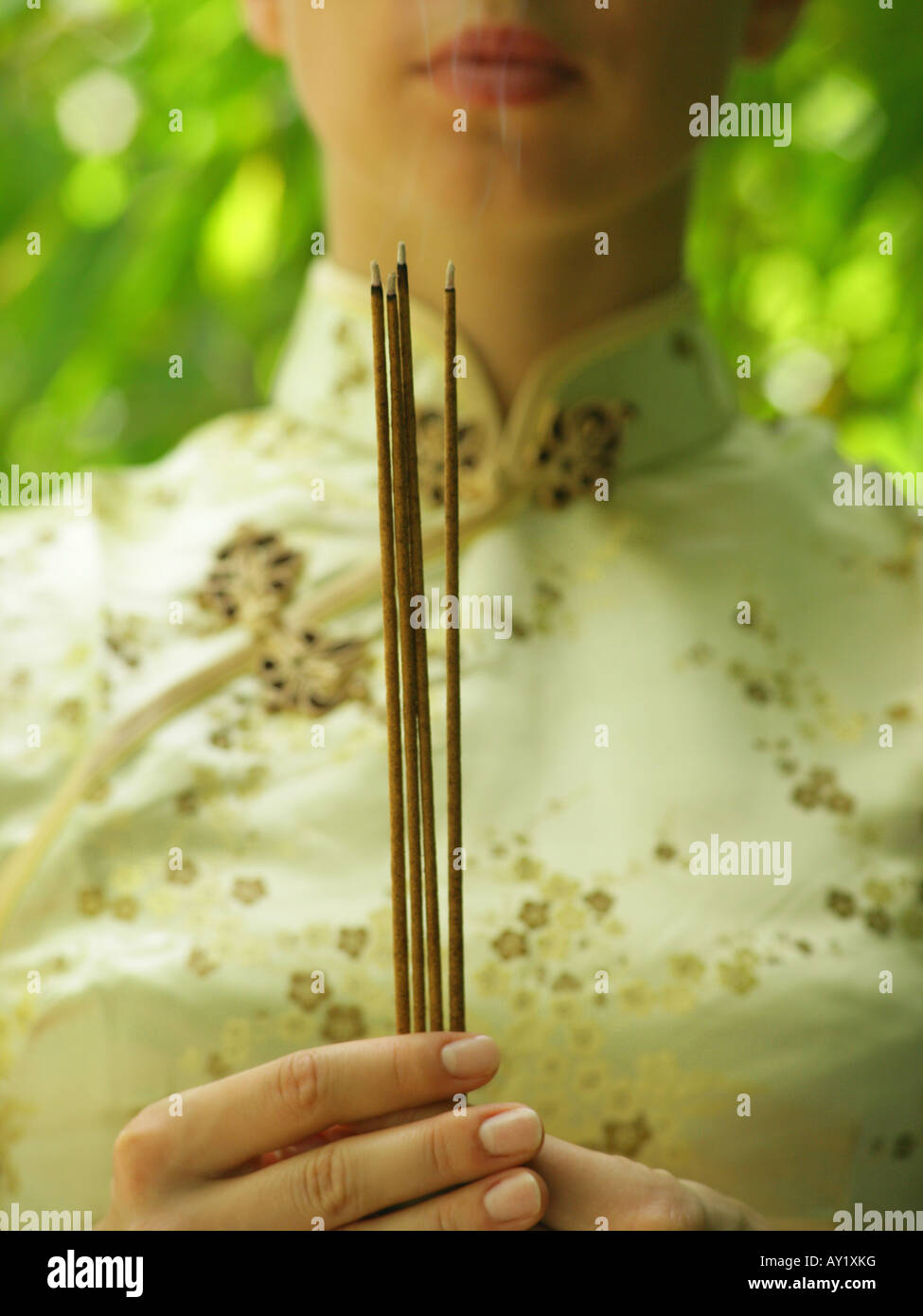 Close-up of a young woman holding incense sticks Stock Photo - Alamy