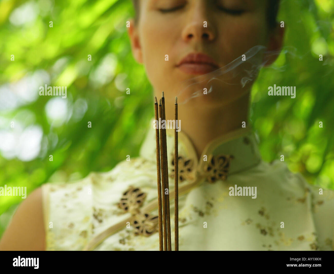 Close-up of a young woman holding incense sticks Stock Photo - Alamy