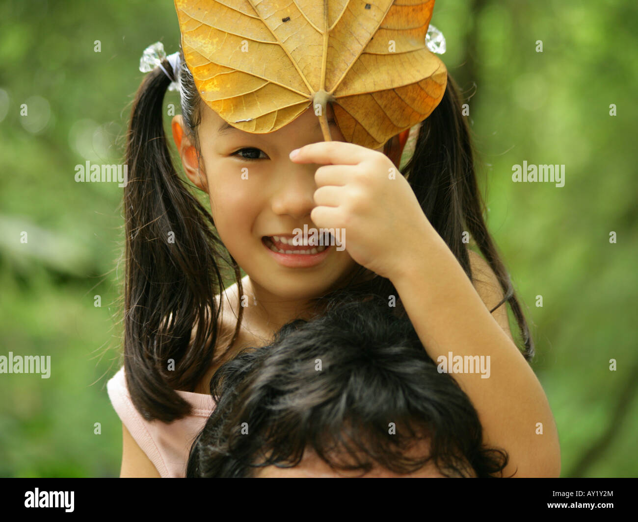 Portrait of a girl holding a leaf Stock Photo - Alamy