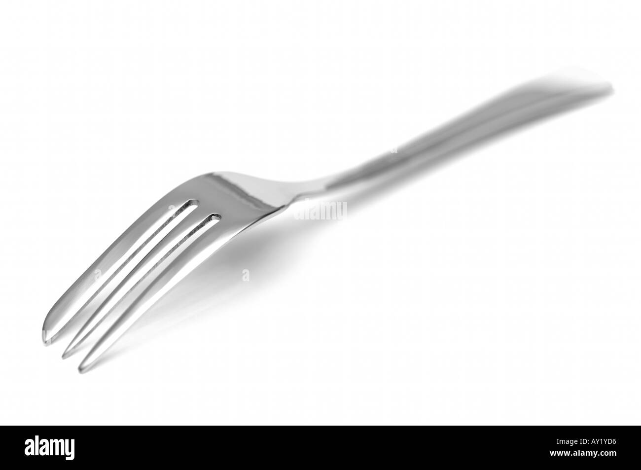 Upside down stainless steel dessert fork on white background shallow depth  of field Stock Photo - Alamy