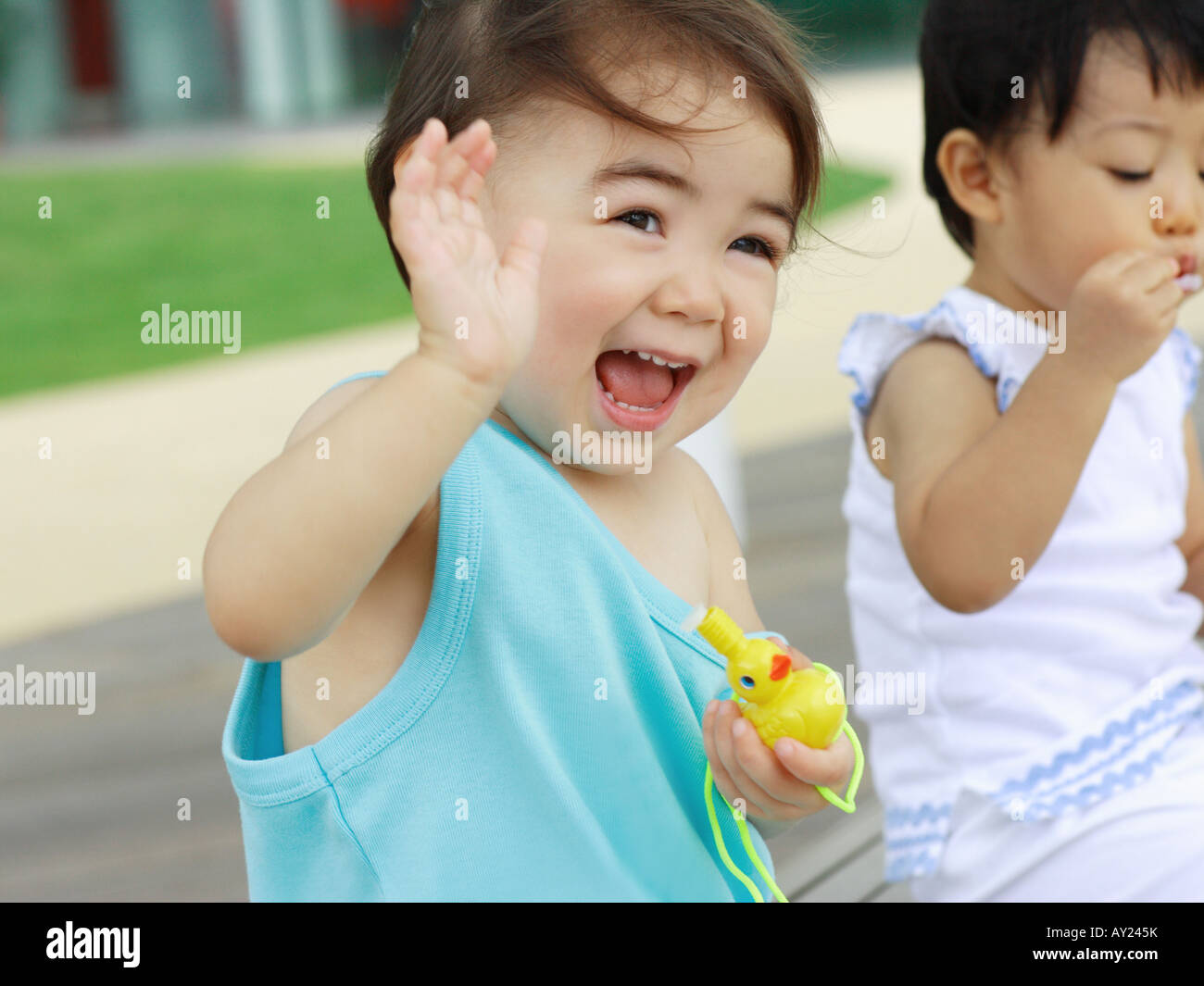 Close-up of two baby girls holding toys Stock Photo - Alamy
