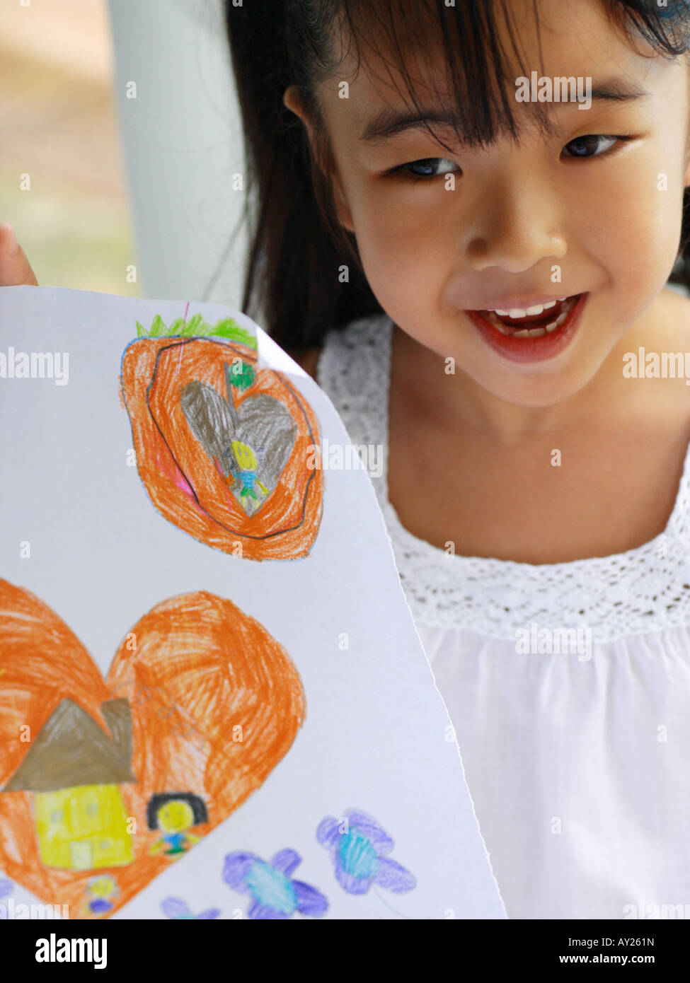 Close-up of a girl holding a crayon drawing Stock Photo