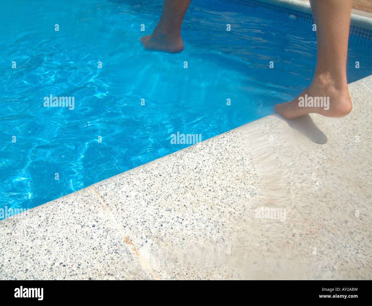 Woman jumping to a swimming pool Stock Photo