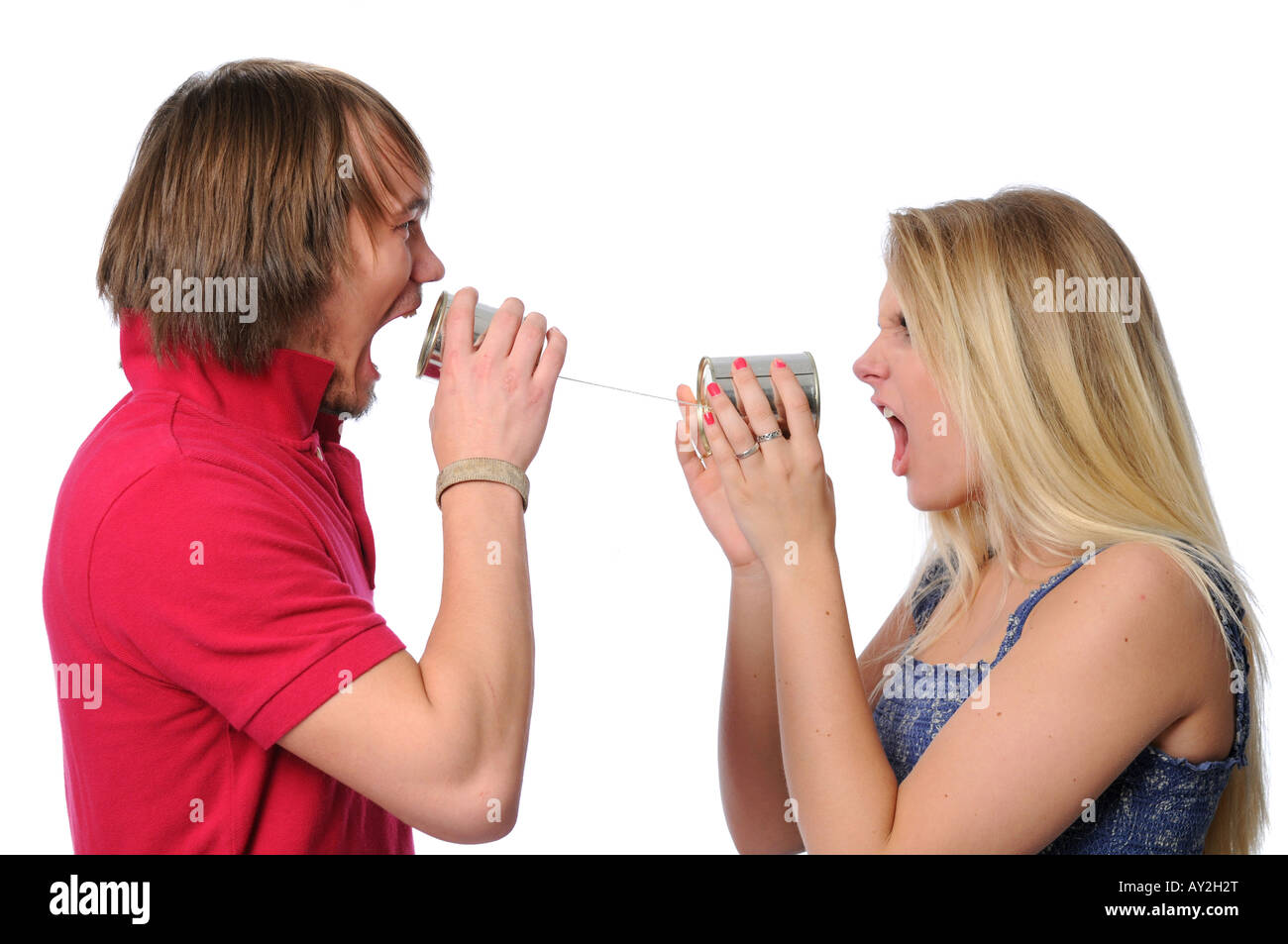Young couple using tin can phone in an argument Stock Photo
