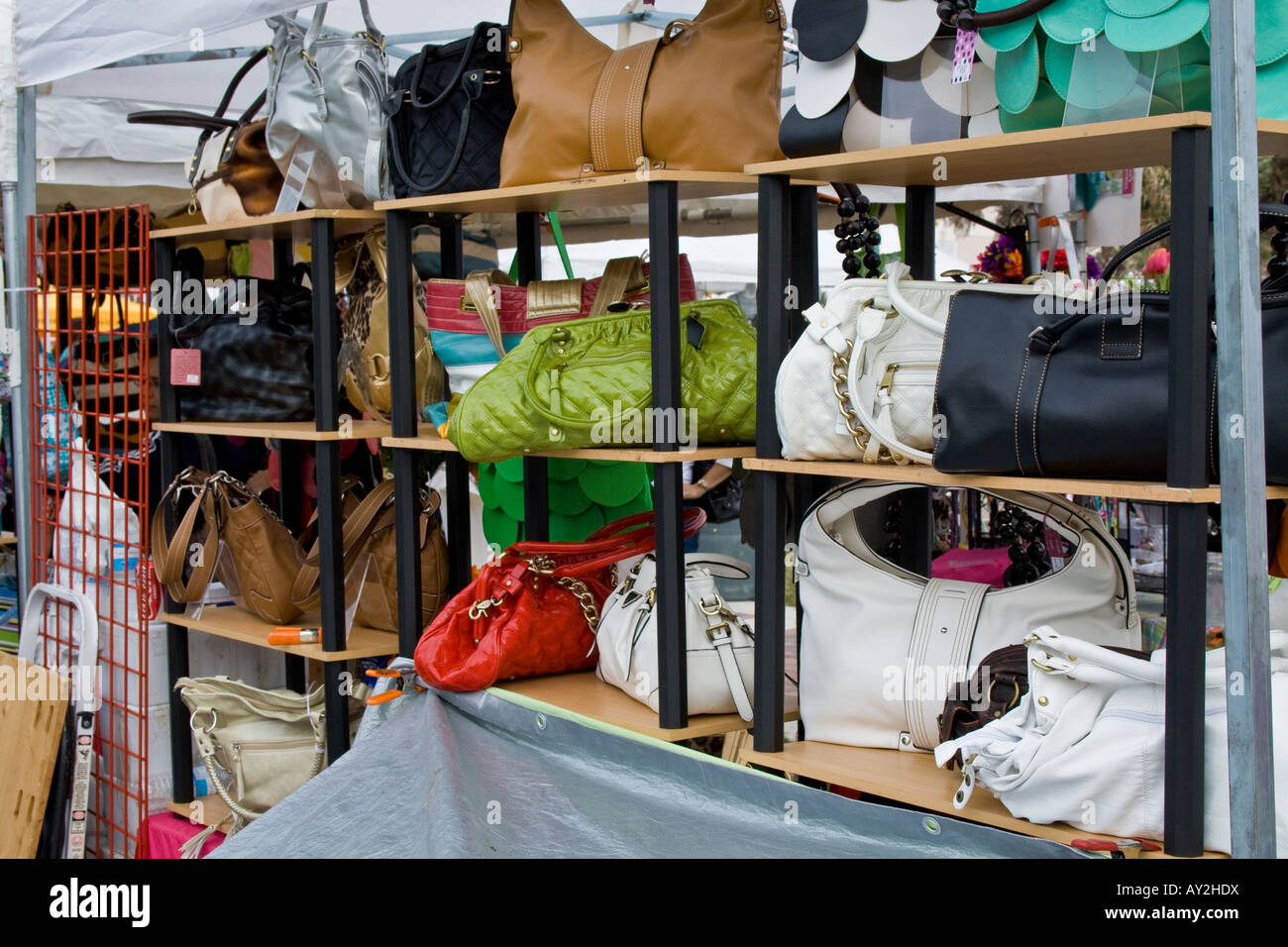 Display of multi-colored purses on three wooden racks for sale Stock Photo