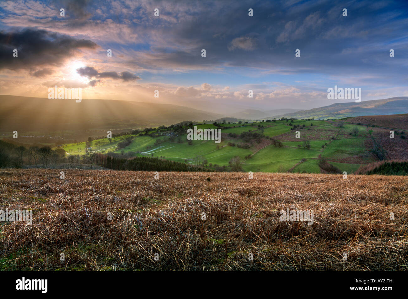 Fingers of evening sunlight strike the beautiful green fields of the Black Mountains of South Wales Stock Photo