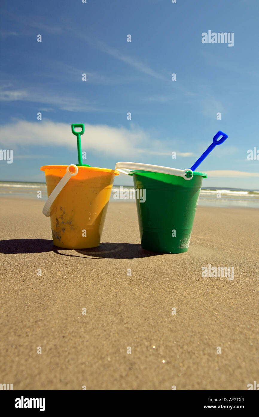 two sand pails at the beach with shovels Stock Photo