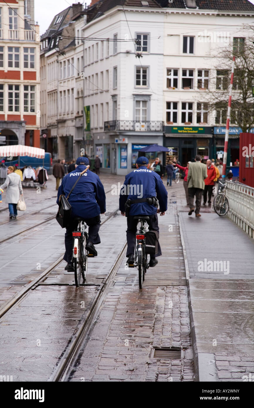 Police officers on a wet cobbled street, with tram lines, in Ghent, Belgium. Stock Photo