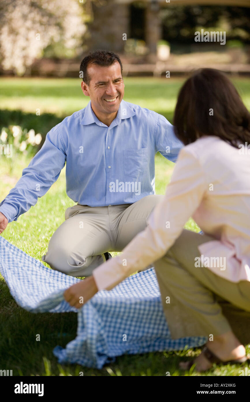 Hispanic couple laying down picnic blanket Stock Photo Alamy