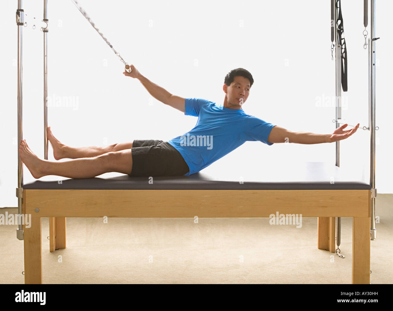 Asian man stretching on exercise equipment Stock Photo Alamy