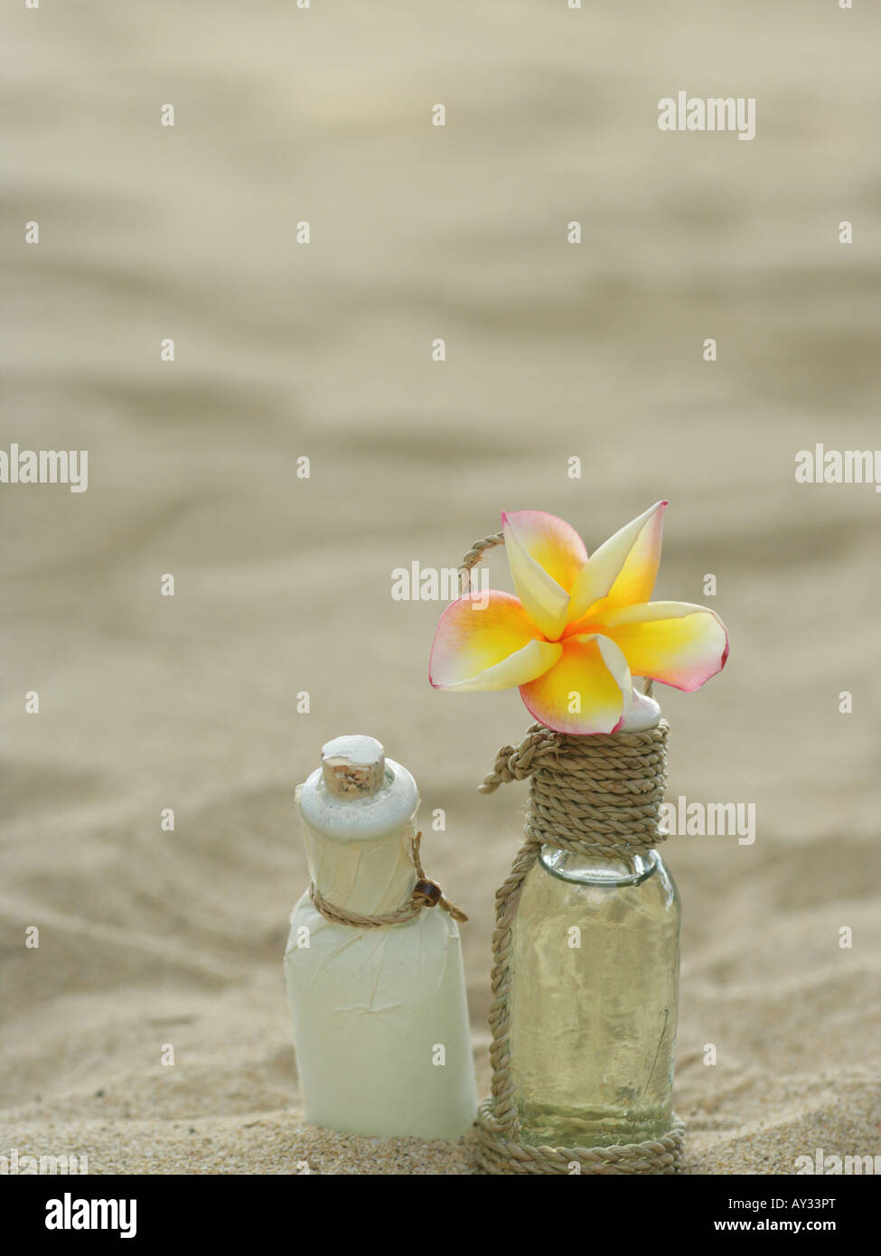 High angle view of a Frangipani flower with two bottles of massage oil (Plumeria) Stock Photo