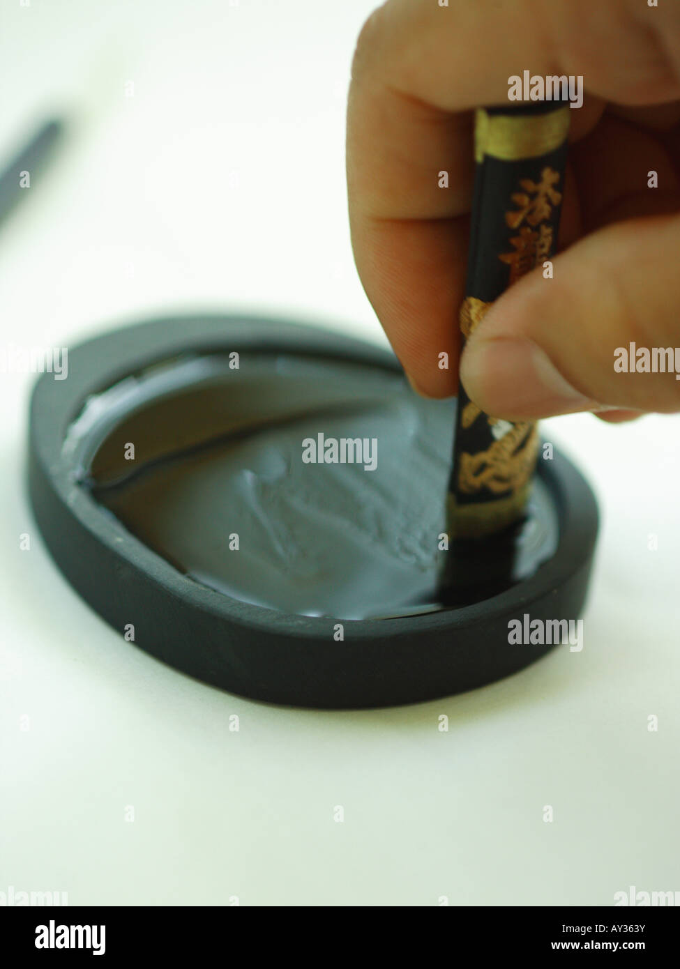 Close-up of a person's hand holding a ink stone Stock Photo