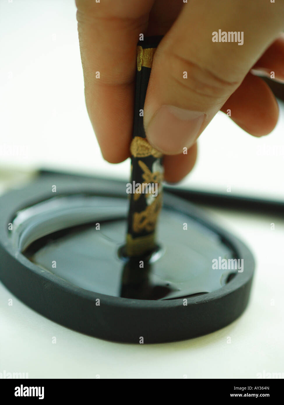 Close-up of a person's hand holding a ink stone Stock Photo