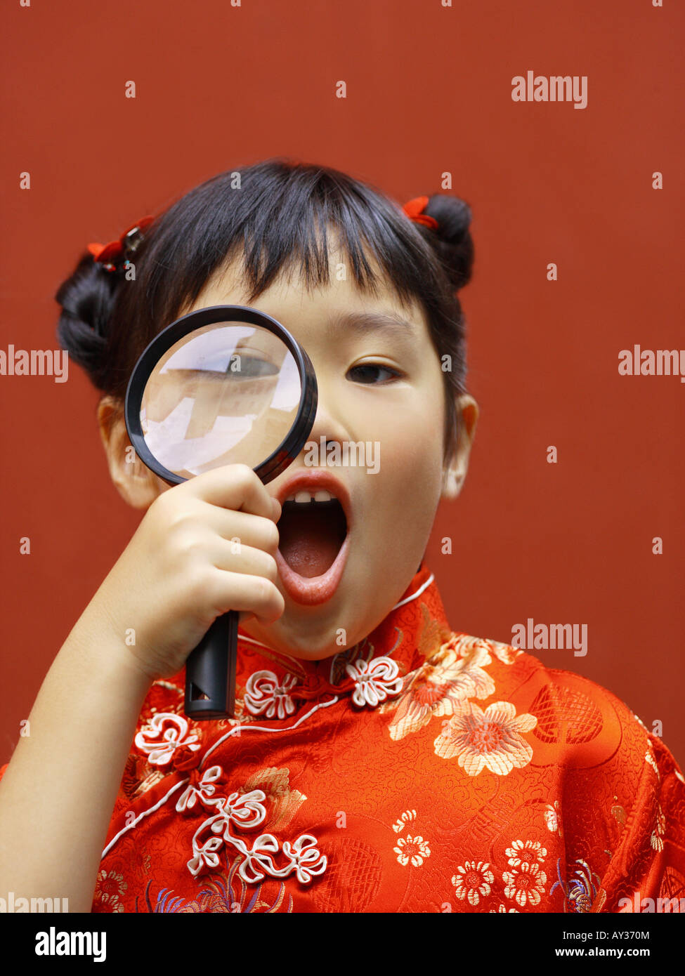 Portrait of a girl looking through a magnifying glass Stock Photo