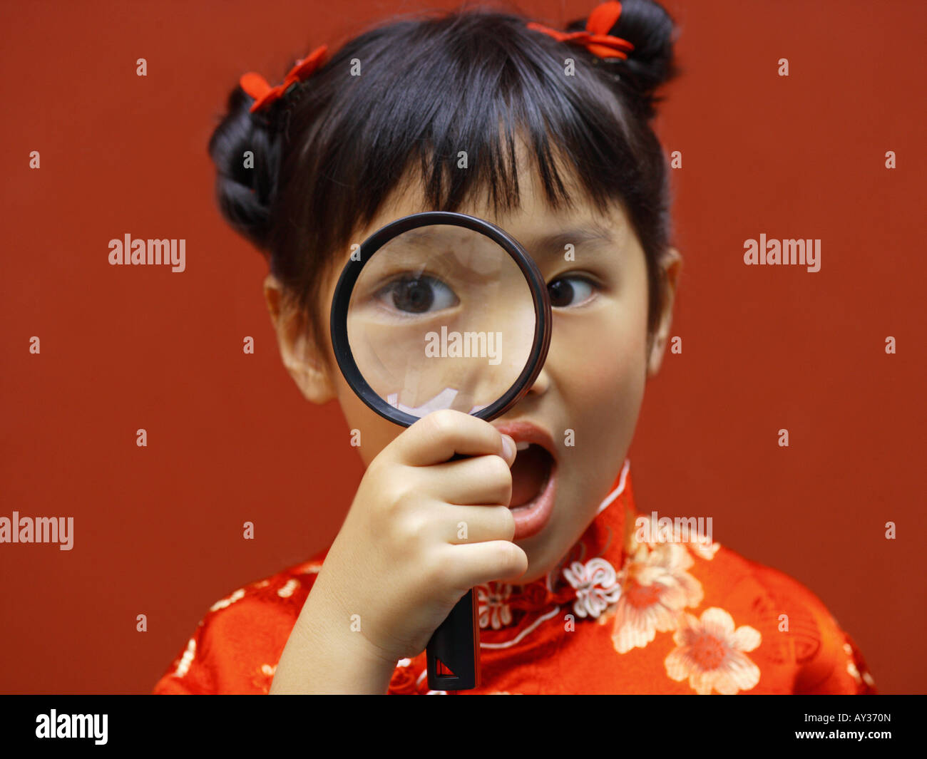 Portrait of a girl looking through a magnifying glass Stock Photo