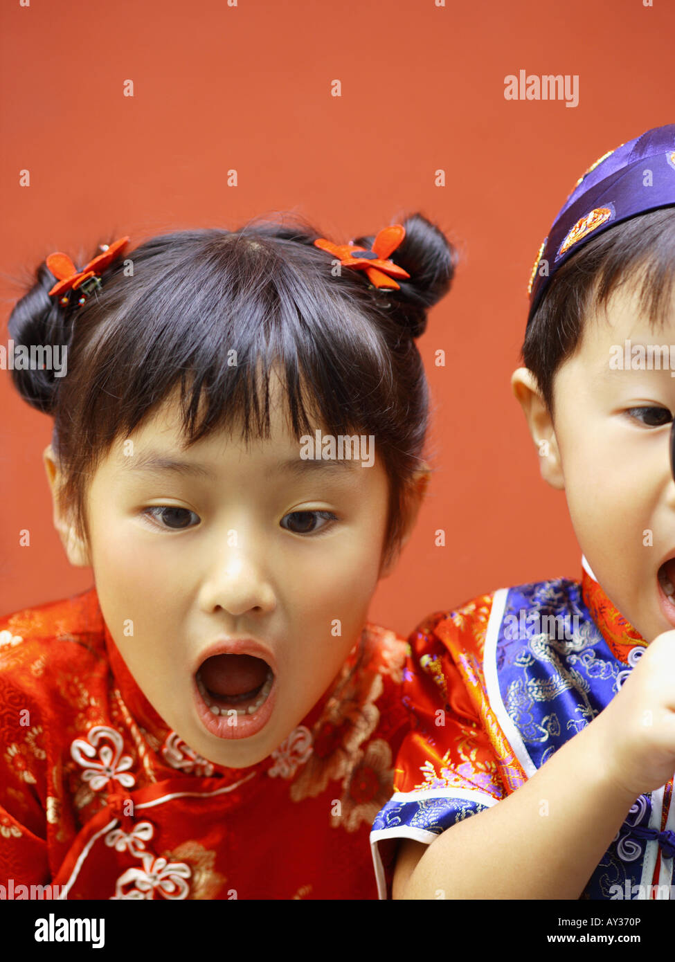 Close-up of a boy looking through a magnifying glass with his sister beside him Stock Photo
