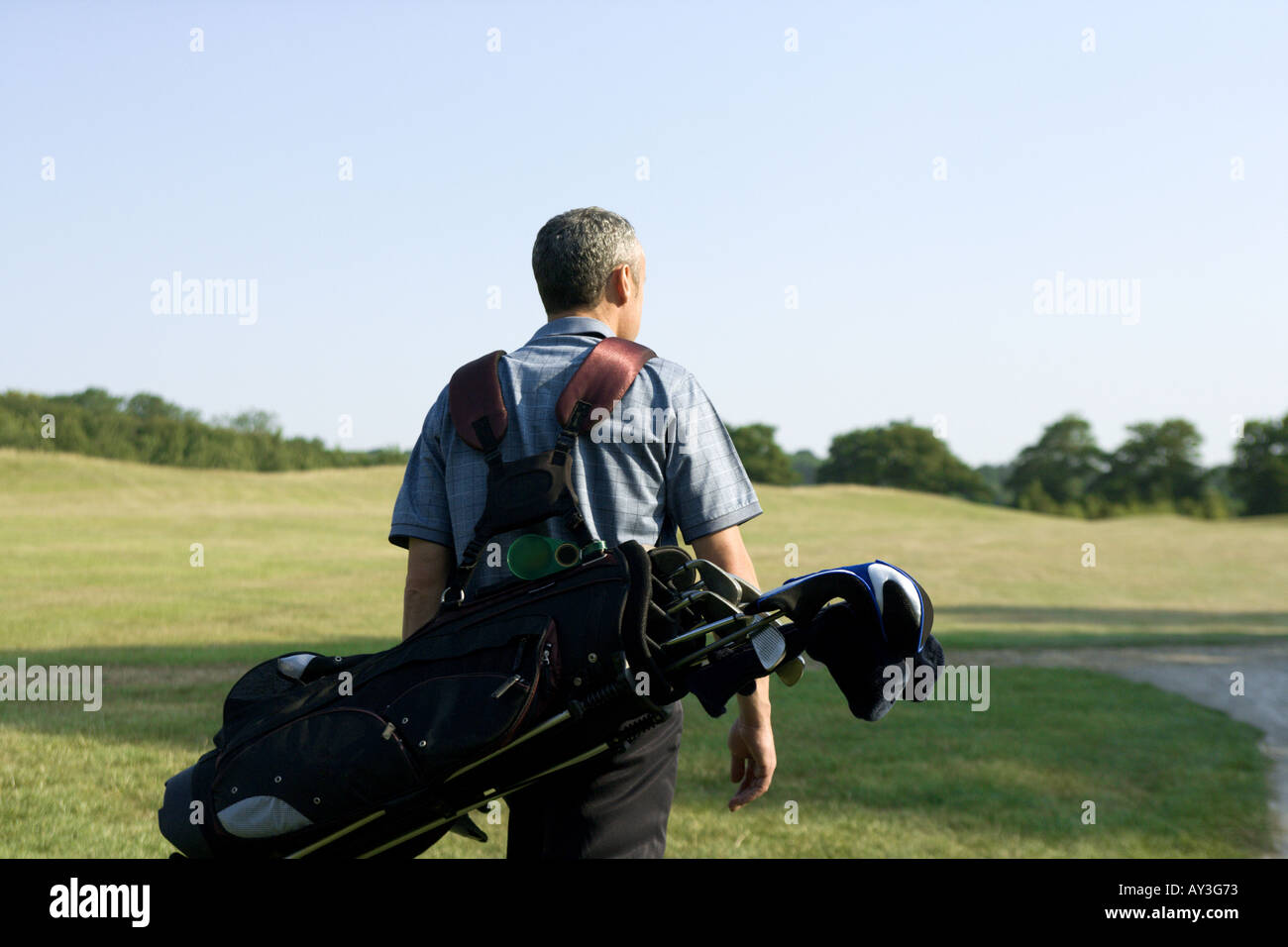 A male golfer carrying golf bag Stock Photo Alamy