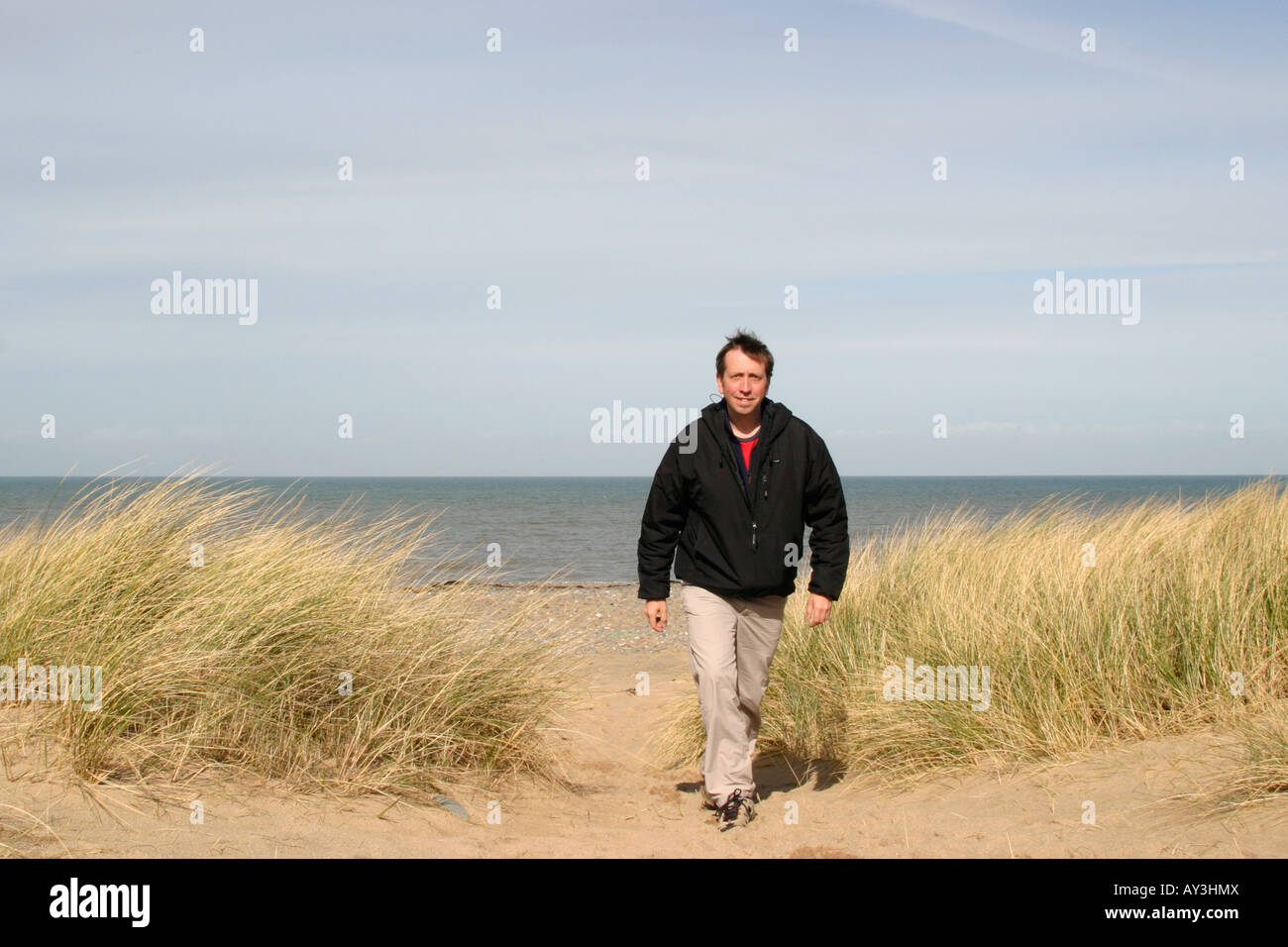 A Man Walking On The Beach At Point Of Ayres Nature Reserve Isle Of a-man-walking-on-the-beach-at-point-of-ayres-nature-reserve-isle-of