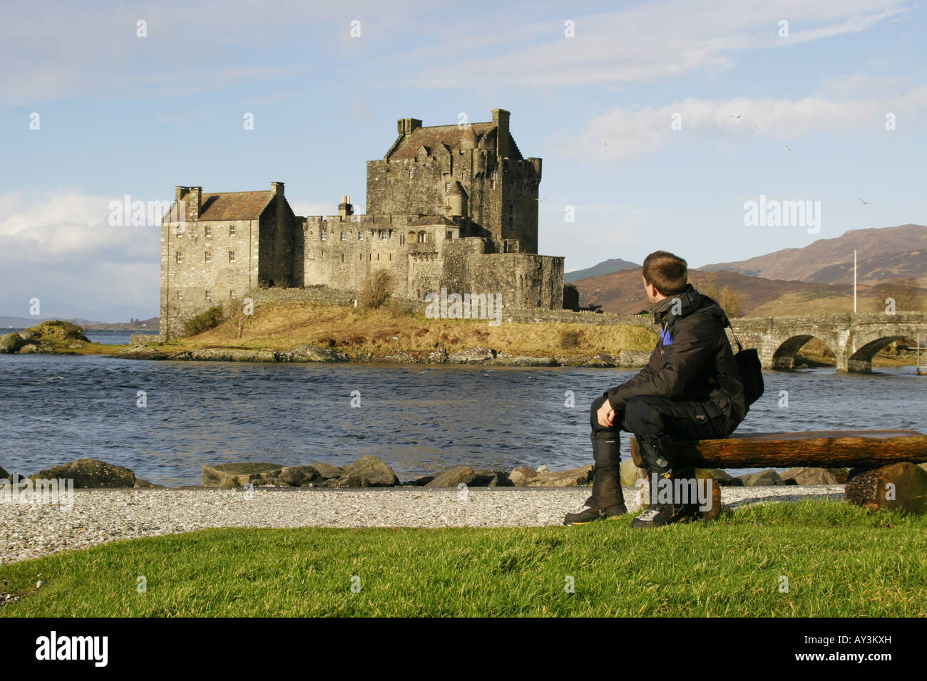 A walker admires Eilean Donon Castle on the shores of Loch Duich, Kintail, Scotland Stock Photo