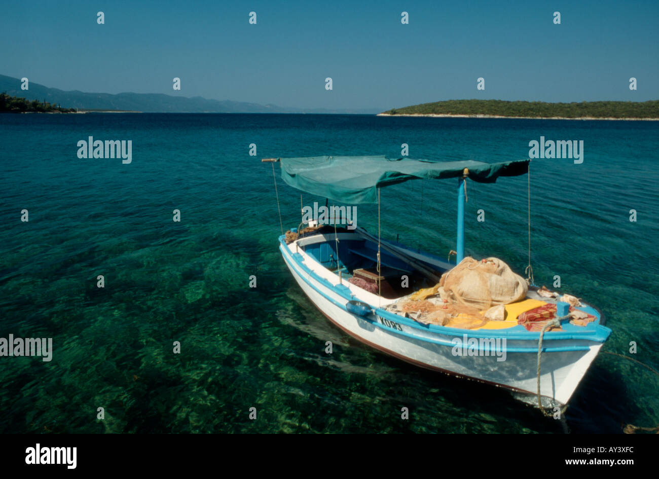 Loviste Village, Peljesac Peninsular, Croatia. Small private fishing boat tied up in lagoon. Clear calm water Stock Photo