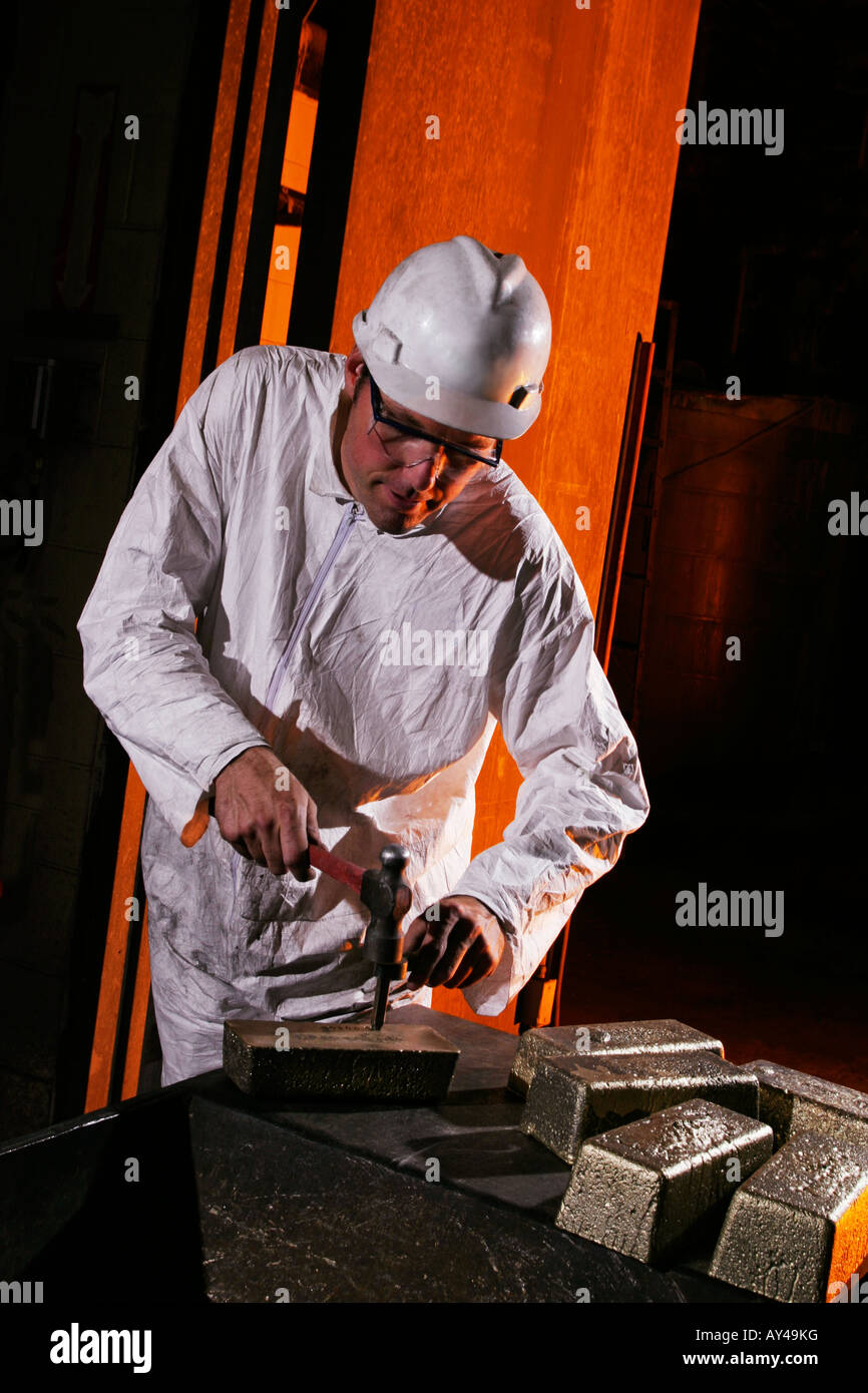 Goldroom refiner stamping gold bars with identication mark in refinery after goldpour, USA Stock Photo