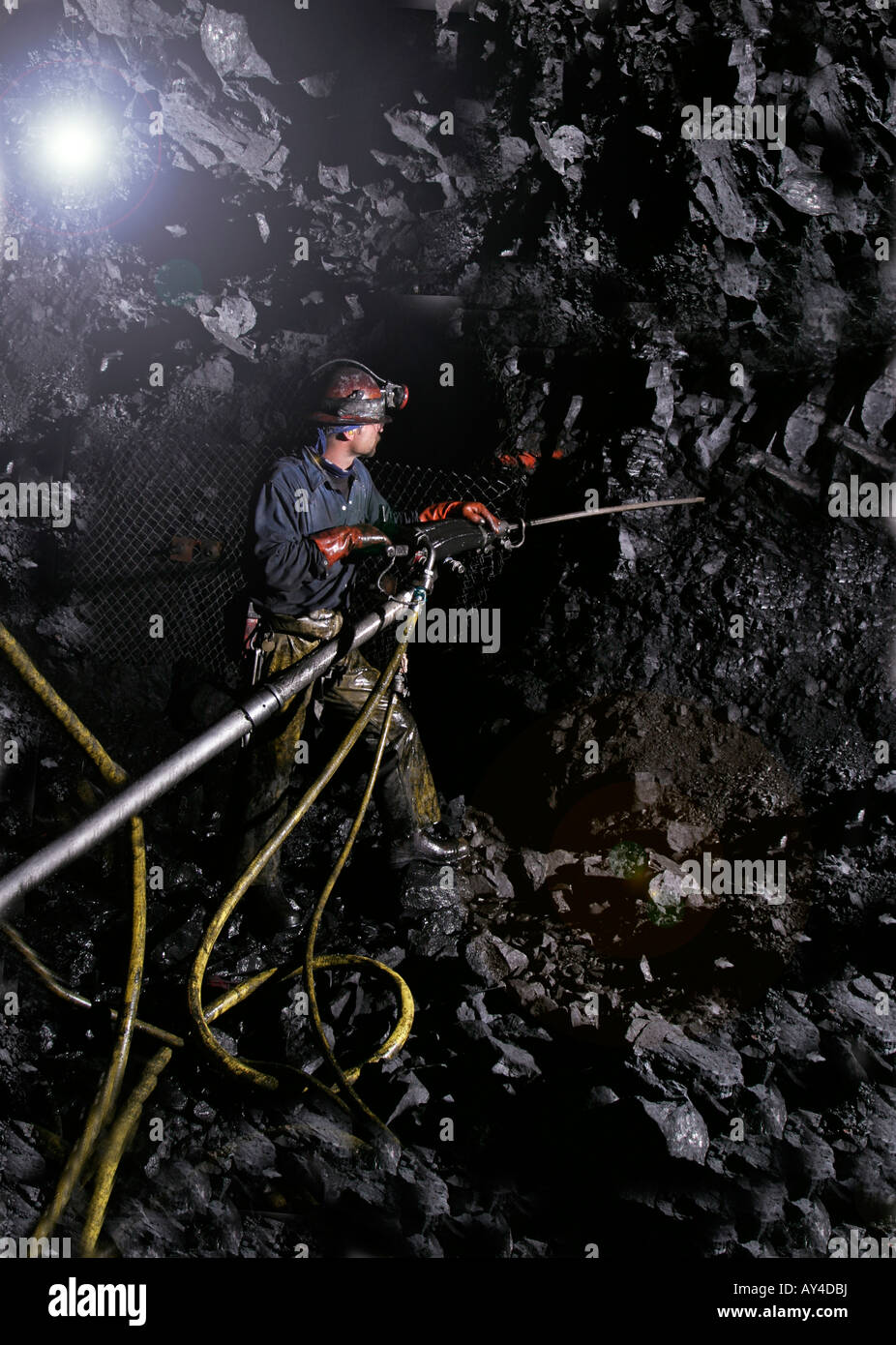 Drilling holes using jumbo drill before rock bolt installation during new underground gold mine construction, USA Stock Photo