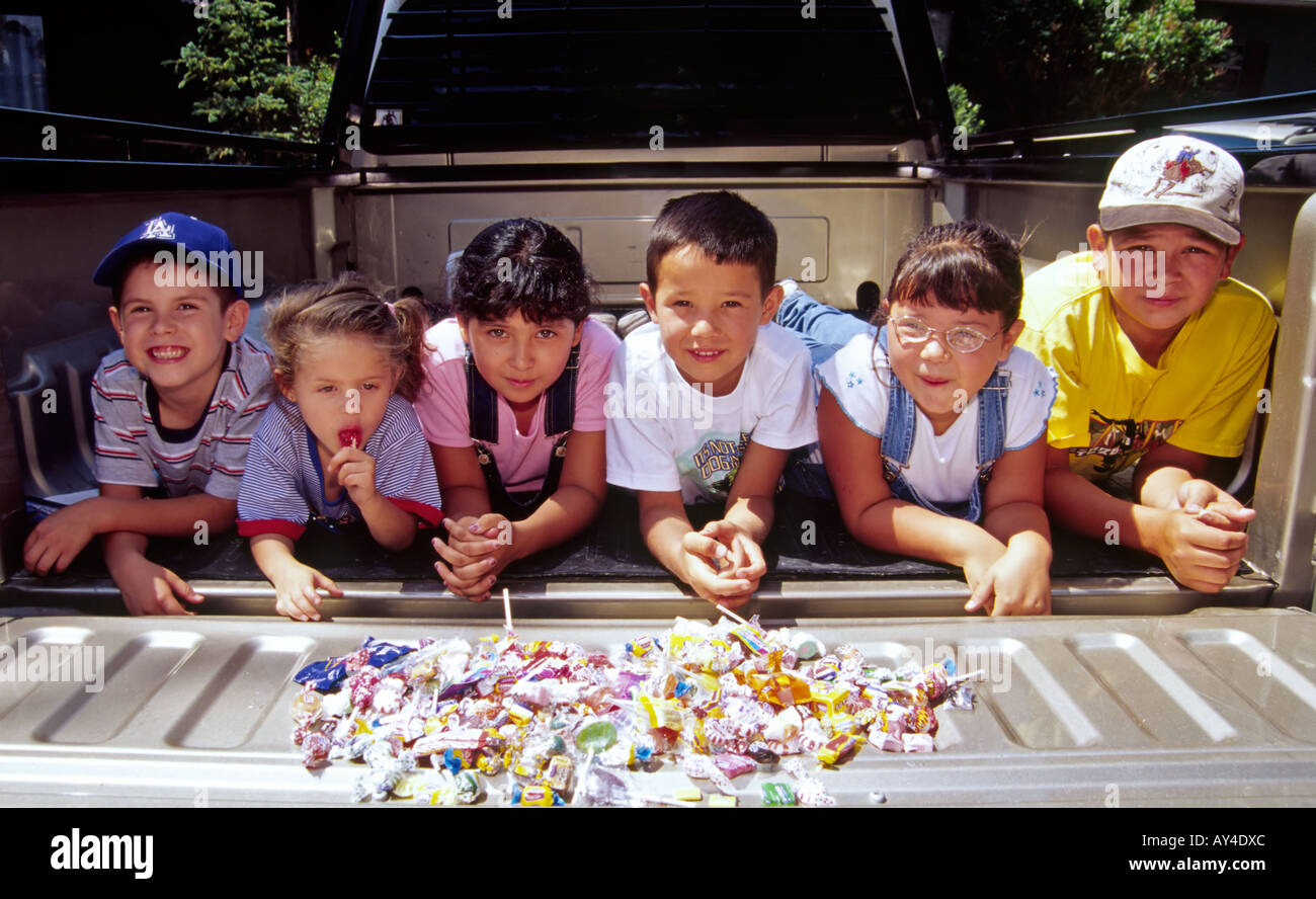 Hispanic children display all their candy gathered at the 4th of July parade in Capitan, New Mexico. Stock Photo