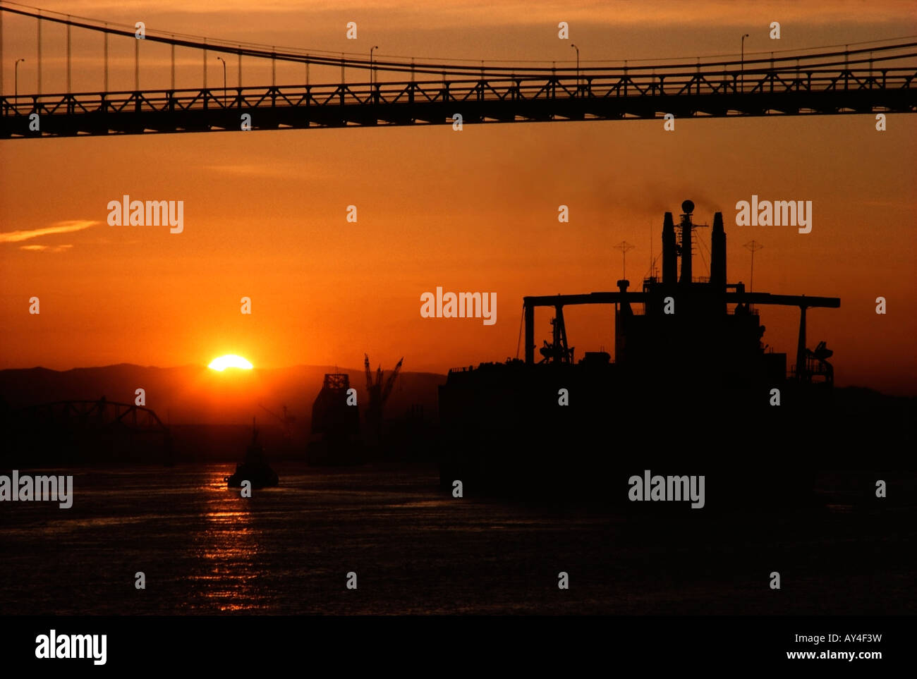 Tug Boat guides an empty Supertanker under a bridge on the Willamette River in Oregon. Stock Photo