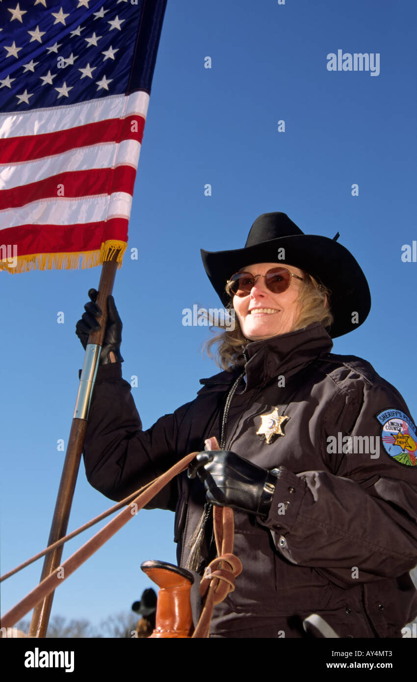 A Lincoln County Sheriff's Posse member carries the American flag at