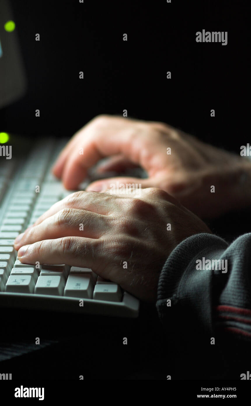 Man using computer hands illuminated by computer monitor Stock Photo ...
