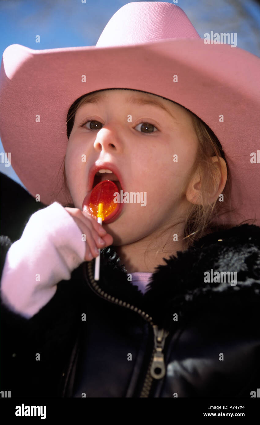 This cute cowgirl is enjoying her Christmas candy, at the annual Cowboy Christmas parade and celebration in Capitan, New Mexico. Stock Photo